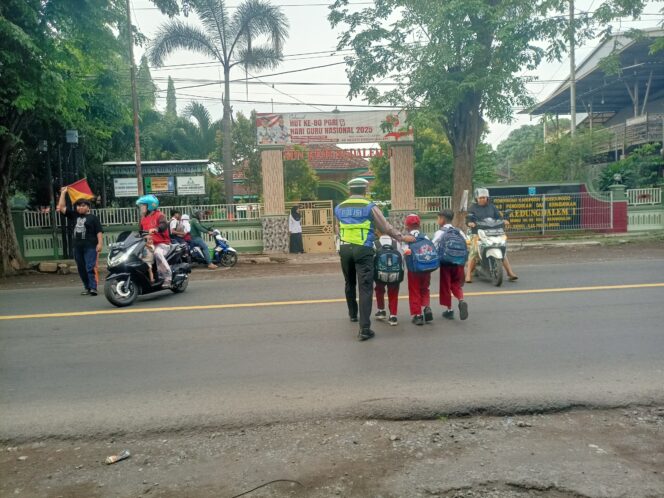 
Poros Pagi Satlantas Probolinggo, Polisi Bantu Pelajar Menyeberang di Tengah Padatnya Pantura