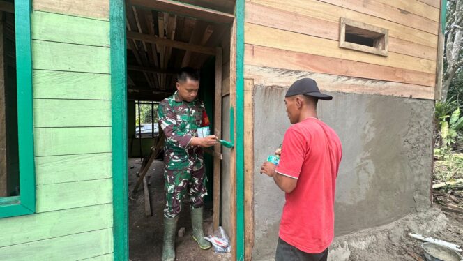 
Dan SSK Satgas TMMD Bantu Pengecatan Kusen Pintu RTLH di Kampung Linggang Amer